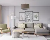 Salón moderno con sofá gris, sillón verde y tres cuadros con motivos botánicos, mostrando diferentes formas de poner cuadros en la pared.