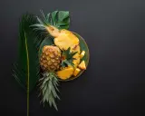 Ananas na talerzu, obok liści. Czy wiesz, że bromelaina co to za enzym?