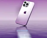 Elegancki, fioletowy iPhone 14 z potrójnym aparatem unosi się nad wodą, odbijając się w jej tafli.