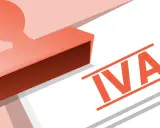 Sello rojo sobre papel blanco con la palabra "IVA" en naranja. El sello parece aprobar o registrar algo relacionado con el IVA.