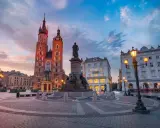 Kraków co warto zobaczyć: Rynek Główny z Kościołem Mariackim i pomnikiem Mickiewicza o zachodzie słońca.