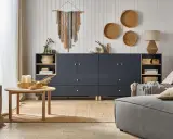 Salon w stylu boho, gdzie beż i granat tworzą przytulną atmosferę. Na ścianie makrama, a na podłodze juta.