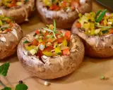 Champignons farcis aux poivrons colorés et herbes fraîches, prêts à être dégustés.