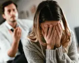 Kobieta płacze, zakrywając twarz dłońmi. Mężczyzna w białej koszuli i krawacie gestykuluje, jakby tłumaczył, jak zerwać z dziewczyną.