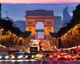 Trafikkaos vid Triumfbågen i Paris. En kvällspromenad här känns som att bada i Paris ljus.