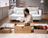 Donna fa decluttering, dividendo vestiti in scatole "Keep", "Donate" e "Discard".