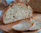 Frisches Brot ohne Sauerteig, mit knuspriger Kruste und luftiger Krume, liegt auf einem Holzbrett.