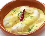 Bacalao al pil pil, uno de los platos típicos vascos, servido en cazuela de barro con ajo y guindilla.