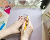 Manos midiendo con regla y lápiz para crear un sobre de papel A4.