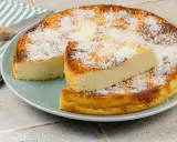 Un délicieux flan coco, saupoudré de noix de coco râpée, est servi sur une assiette. Une part est coupée et posée sur le dessus.