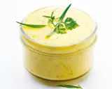 Sauce béarnaise onctueuse dans un bocal, garnie d'herbes fraîches. Parfaite pour accompagner vos plats, cette recette est un délice.