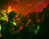 Persone che ballano in un locale notturno, luci stroboscopiche e musica alta: il vero clubbing significato.