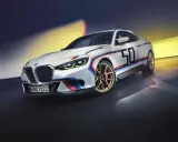 Sportlicher BMW 3.0 CSL in Weiß mit M-Streifen und der Startnummer 50 auf goldenen Felgen.