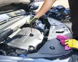 Sprawdzanie poziomu oleju silnikowego przed zmianą z 5w40 na 5w30. W tle widać motocykl.