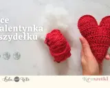 Czerwone serce na szydełku, gotowe na walentynki. Obok kłębek czerwonej włóczki i białe wypełnienie.