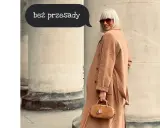 Kobieta w beżowym płaszczu i okularach przeciwsłonecznych, z małą torebką, prezentuje seksowny ubiór na co dzień.