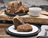 Saftiger **Diabetiker Kuchen** auf rustikalem Holzbrett, serviert auf Tellern mit Gabel.
