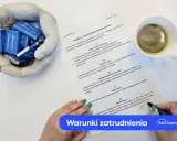 Dokument informujący o warunkach zatrudnienia, z czekoladkami "360 Kadry i płace" w dłoniach i filiżanką kawy.