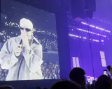 Sobel na ekranie, tłum z telefonami tworzy fiołkowe pole świateł. Koncert w fioletowej poświacie.
