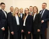 Grupa prawników w garniturach pozuje do zdjęcia.