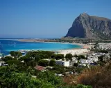 Vista panoramica di San Vito Lo Capo, con la spiaggia affollata e il Monte Monaco. La distanza da Cefalù è di circa 100 km.
