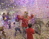 Niños celebrando con confeti en Valencia hoy. ¡Una fiesta llena de color y alegría!