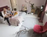 Familjen myser i sängen, pappan läser en bok för barnen. Ett litet bo med barn som njuter av stunden.