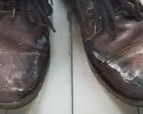 Zimowe buty skórzane pokryte białym nalotem po soli. Dowiedz się, jak usunąć sól z butów skórzanych, by przywrócić im dawny blask.