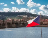 Flaga Czech na tle Mostu Karola w Pradze. Zastanawiasz się, ile idzie paczka z Czech do Polski?