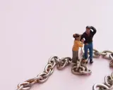 Figuras de pareja unidas por una cadena, simbolizando la codependencia de pareja.