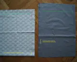 Dwa kawałki materiału na podłodze, jeden z rybkami, drugi szary. Pokazują etapy, jak uszyć plecak, zaznaczone linie i miejsca do zszycia.