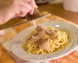 Un piatto di spaghetti conditi con tartufo fresco, un'esperienza culinaria tipica delle sagre tartufo toscana.