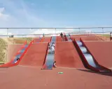 Diversión garantizada: niños y adultos disfrutan de toboganes gigantes. ¡Un plan ideal que hacer con niños en Barcelona!