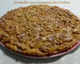Gâteau rustique aux pommes et amandes effilées sur une assiette rose.