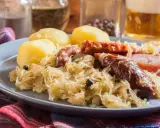 Assiette de choucroute garnie avec pommes de terre, saucisses et lard. Un plat typique de restaurant.
