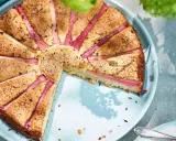 En saftig rabarberkaka med vackert arrangerade rabarberbitar, strödd med socker och kanel. Perfekt för en fika utomhus.