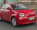Czerwony Fiat 500 jedzie po drodze. Sprawdź aktualną fiat 500 cena i dowiedz się więcej o tym stylowym samochodzie.