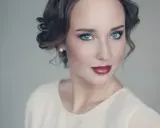Maquillaje para vestido blanco: ojos ahumados y labios rojos intensos, peinado recogido con rizos.