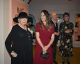 Prinsessan Sofia beundrar en utställning med hattar, där en äldre dam bär en elegant svart hatt.