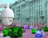 Rodzaje kamer na skrzyżowaniach: biała kamera PTZ nadzoruje ruch uliczny, z zaznaczonymi pojazdami i pieszymi.