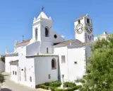 Weiße Kirche mit Glockenturm und Uhr im Herzen der tavira altstadt.