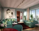 Ett lyxigt vardagsrum med inspiration från art deco i Stockholm. En stor bild av Greta Garbo dominerar väggen, omgiven av turkosa soffor och spegelväggar.
