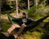 Mężczyzna w hamaku w lesie. To jest właśnie bushcraft – sztuka przetrwania i życia w zgodzie z naturą.