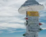 Znak szlaku na Babiej Górze, Diablak 1725 m n.p.m. w zimowej scenerii. Wskazuje kierunki do Sokolicy, Krowiarek i schroniska PTTK.