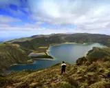 Ein Mann blickt auf eine atemberaubende Kraterlandschaft mit mehreren Seen. Die Frage, ob Madeira zu den Azoren gehört, wird hier durch die Schönheit der Natur beantwortet.