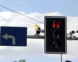 Fotoradar na światłach, czerwone światło dla kierunku na wprost. Obok znak nakazu skrętu w lewo.