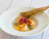 Saint-Jacques poêlées dans une sauce onctueuse, garnies de pousses rouges et d'aneth, accompagnées d'une tuile de sarrasin. Un délice de table à la française.