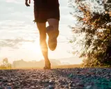 Gambe di un corridore su un sentiero sterrato al tramonto. Ottimo per bruciare calorie corsa 7 km/h.