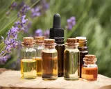Bottigliette di oli essenziali, con lavanda sullo sfondo, che evocano le loro proprietà benefiche e naturali.