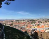 Blick vom Nossa Senhora do Monte auf Lissabon mit seinen roten Dächern und der Brücke im Hintergrund.